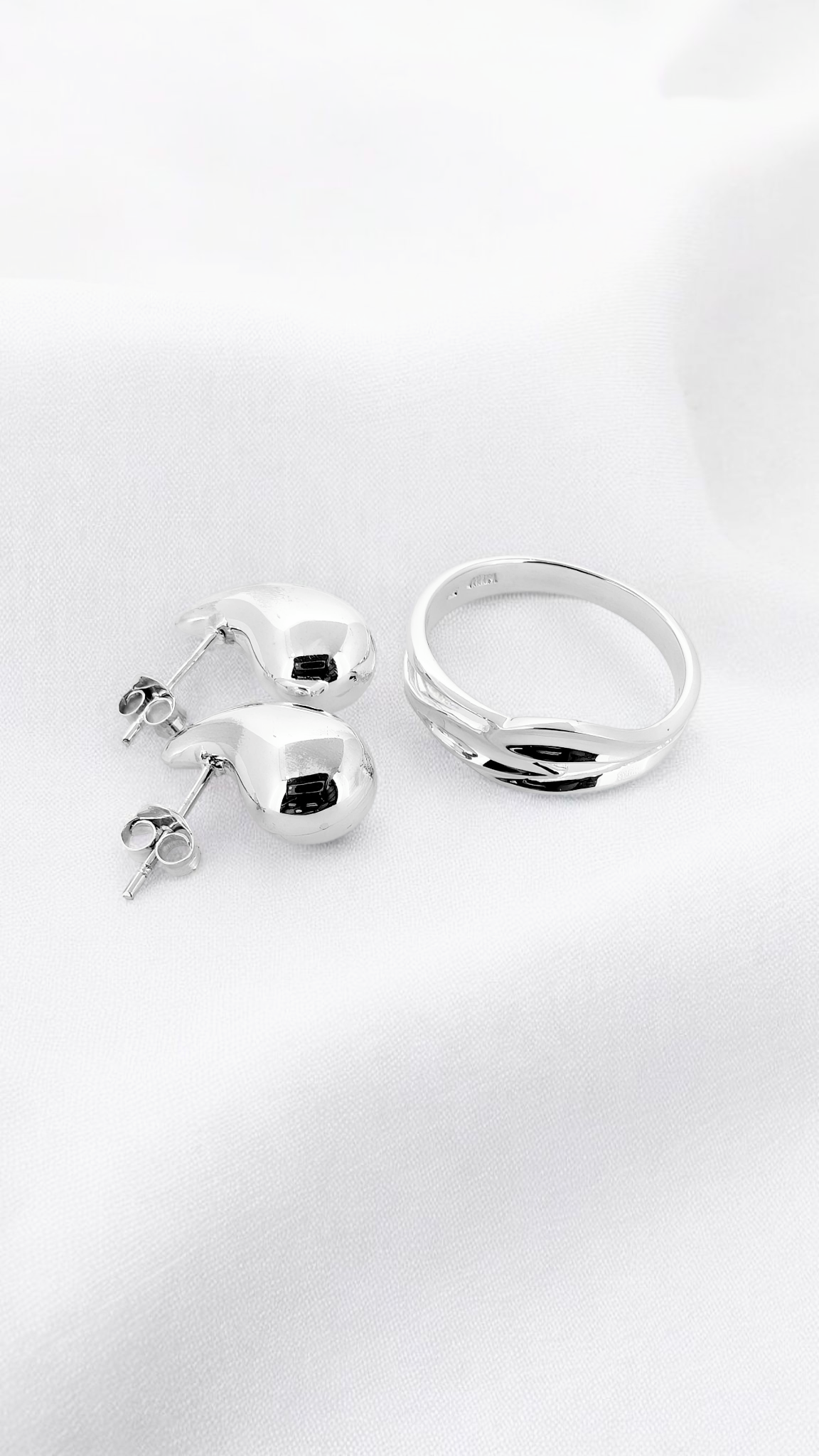 Silver combo - sterling silver ring gracefully entwined in a fluid wave-like design, paired with teardrop studs
